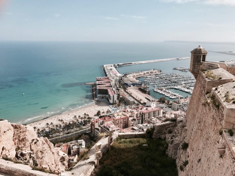 looking down at a harbour and stone pier on the coast in alicante 