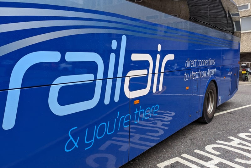 side of a blue bus printed with the words "railair & you're there direct connections to heathrow airport". 