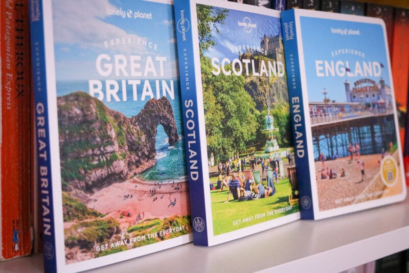 three books on a bookshelf in a row, from left to right the titles are Experience Great Britain, Experience Scotland, and Experience England. gift ideas for travel lovers