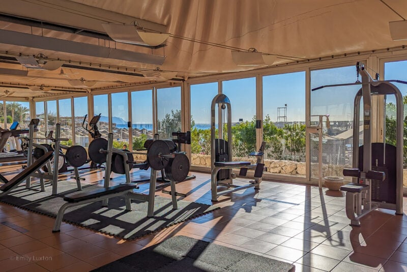interior of a gym with floor to ceiling windows with a view of the blue sky
