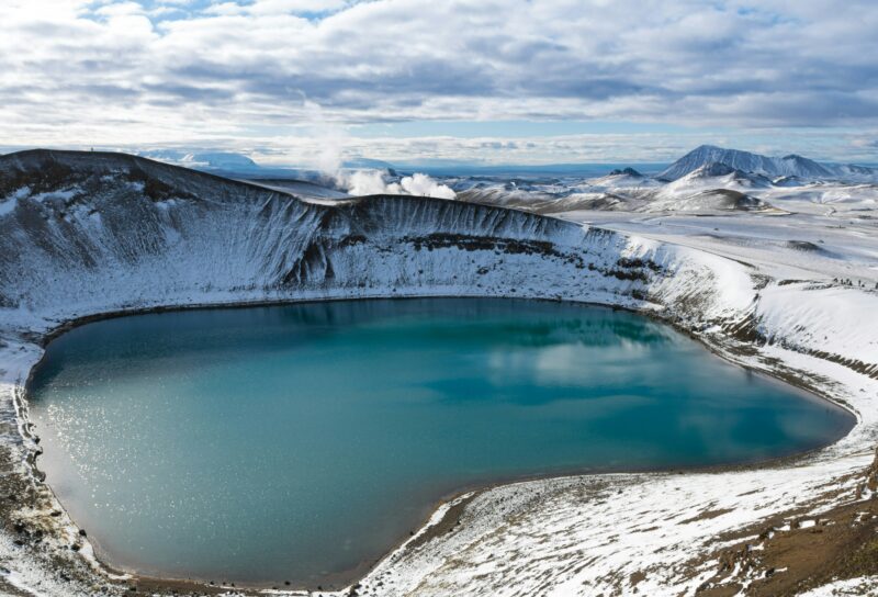 large blue lake surrounded by snowy hills