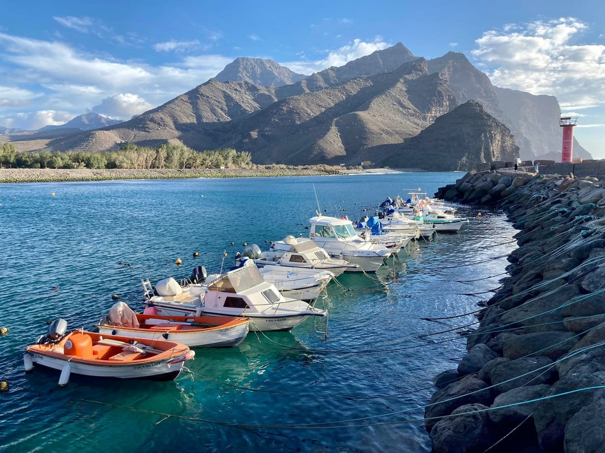 Row of boats in the sea with mountains behind