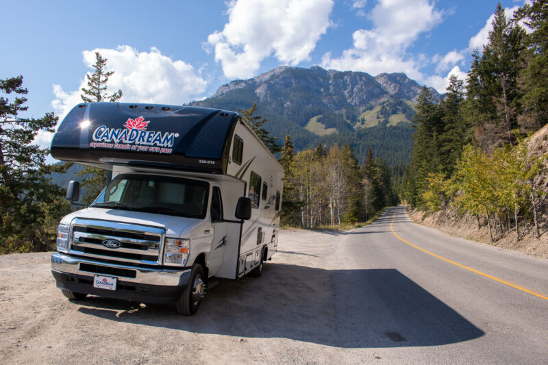Large motorhome parked at the side of a road with a mountain behind | Alberta 1 week Road Trip