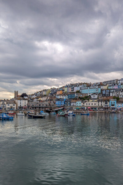 Town wiht many colourful buildings next to a large harbour on a grey day