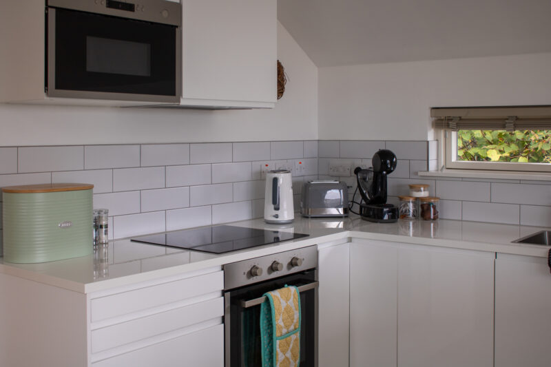 Kitchen with white cupboards and white tiles