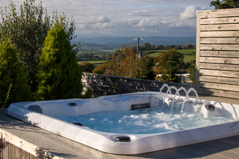 Outdoor hot tub with trees and a view of the countryside beyond