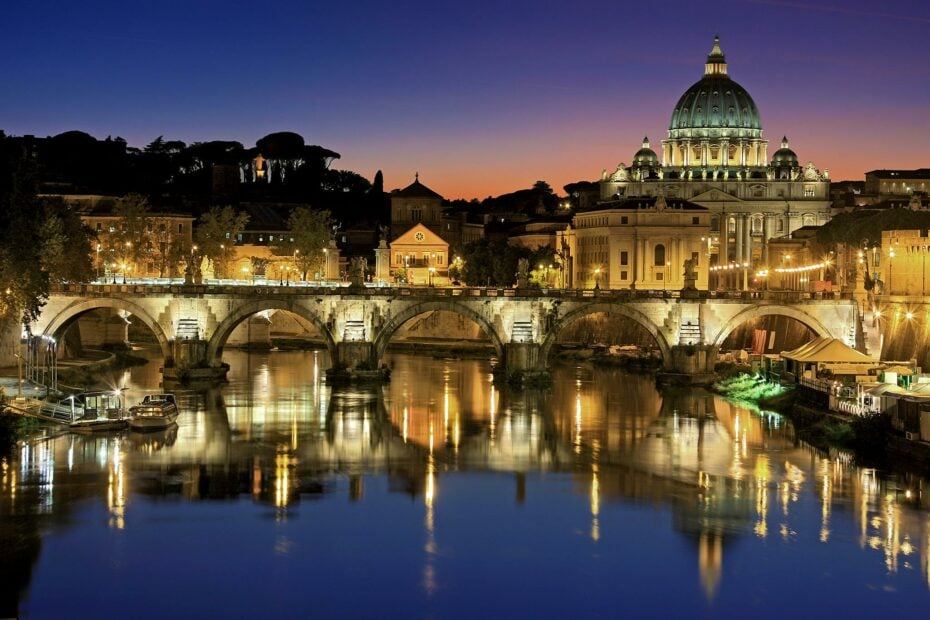 bridge and domed basilica in Rome lit up at night