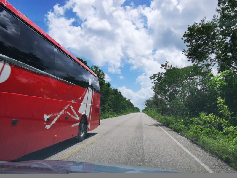ADO bus drives on the highway in the jungle in Chiquila Lazaro Cardenas in Quintana Roo Mexico.
