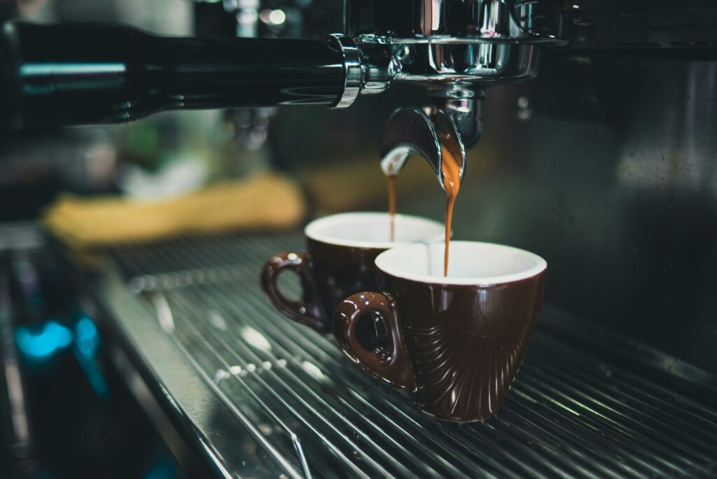 close uo of two coffee cups being filled in an espresso machine