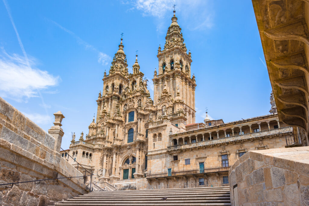 exterior of Santiago de Compostela cathedral, a beige stone building with two carved towers