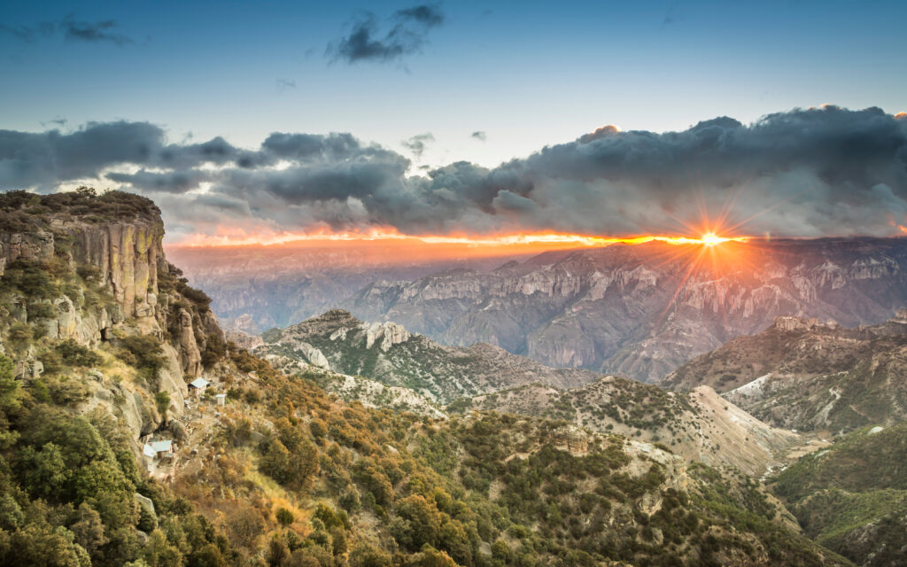 sunrise over the cliffs across a large rocky canyon