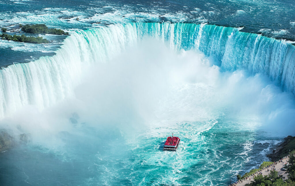 aerial view of horseshor falls at Niagara with a small boat approaching the cloud of spray