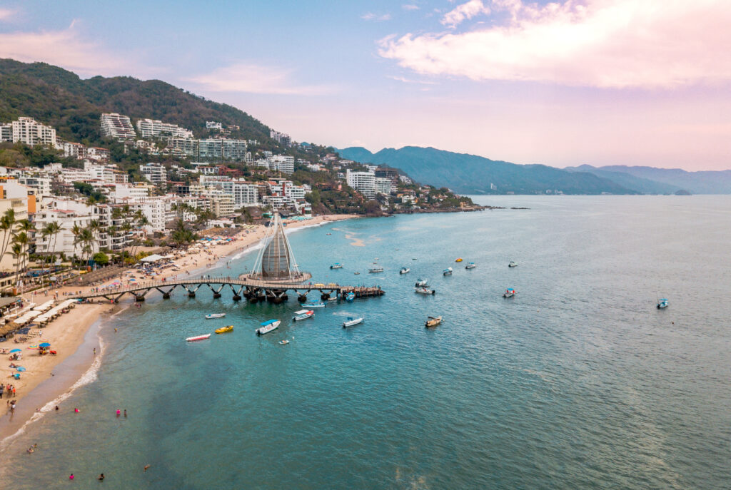 aerial view of coastline with a long beach and a pier