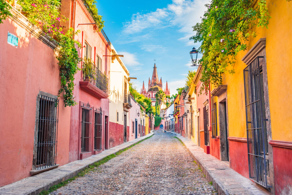 cobbled street lined with buildings painted in orange and pink