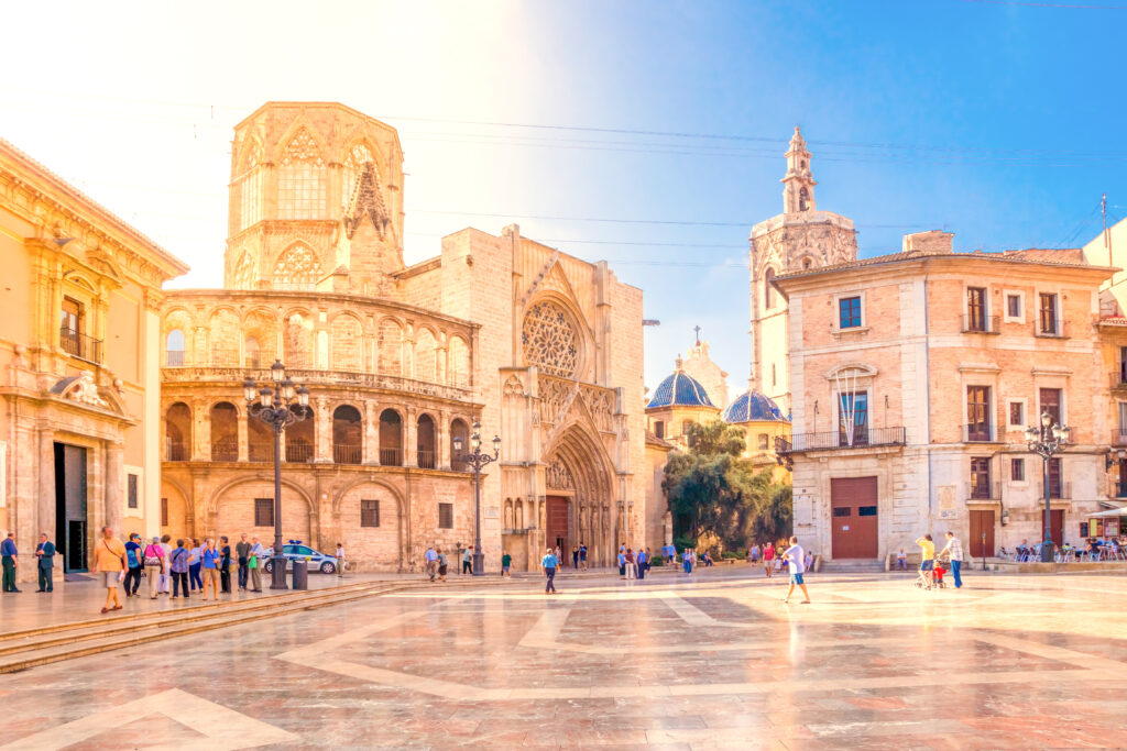 large empty plaza with a cathedral built from pale orange stone