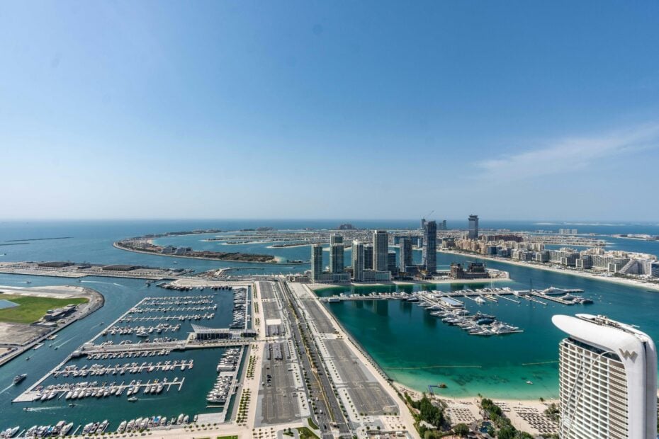 aerial view of dubai with roads and skyscrapers surrounded by turquoise water