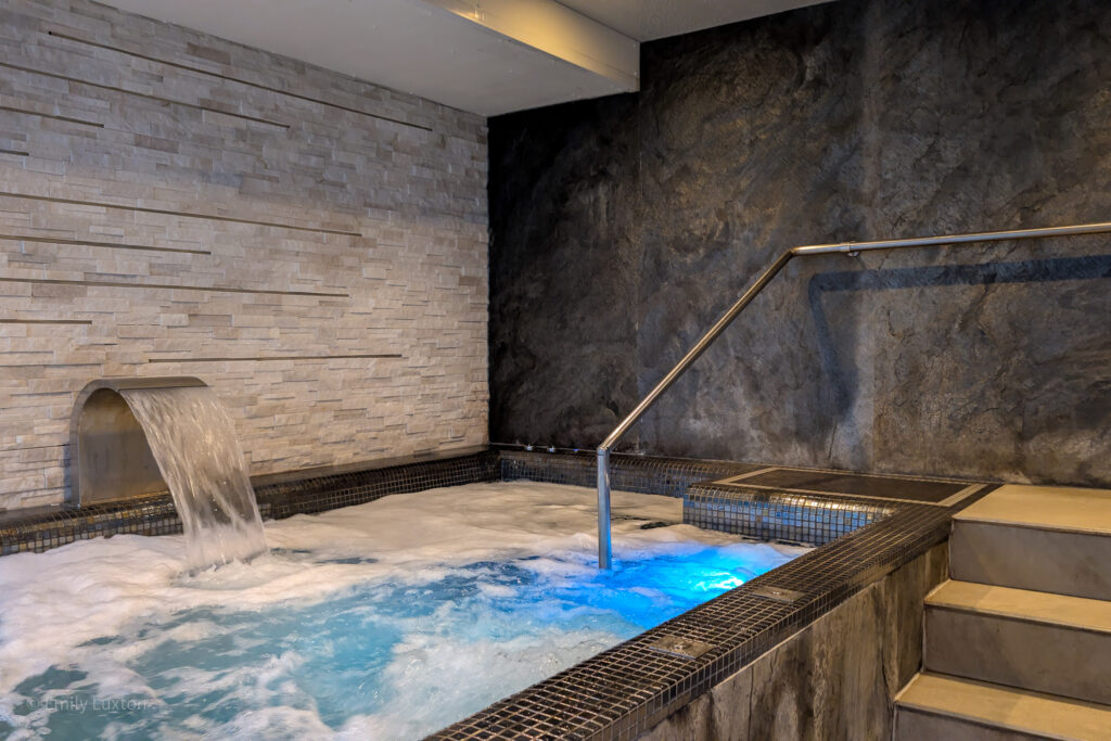 large hydro pool with bubbles surrounded by grey tiled walls