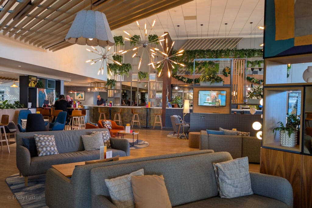 grey sofa in a large hotel lounge space with different coloured armchairs and a bar