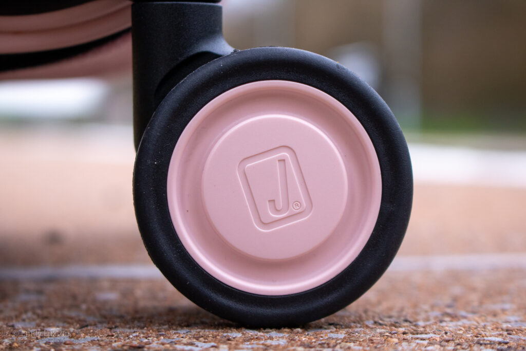 Close up of a black suitcase wheel with a pink centre and a J logo | JOLLYING Pebble suitcases review