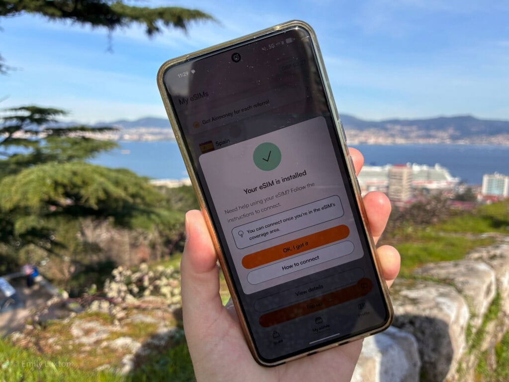hand holding a phone with the message "your esim is installed"