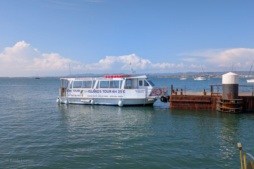 White boat in the blue sea next to a jetty