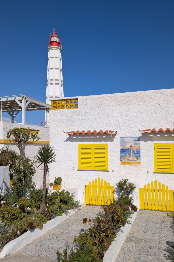 white building with yellow shutters with a white lighthouse behind | 3 days in the algarve