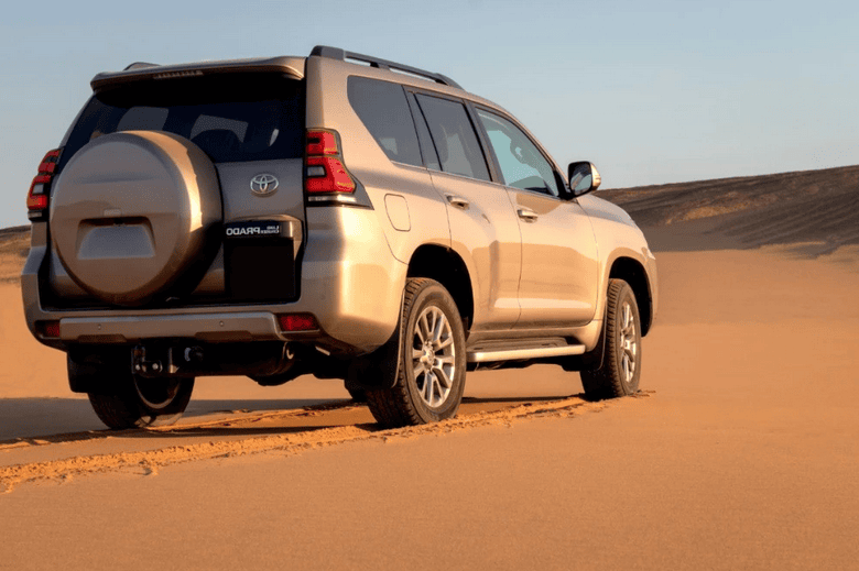 silver jeep driving on sand in the dessert