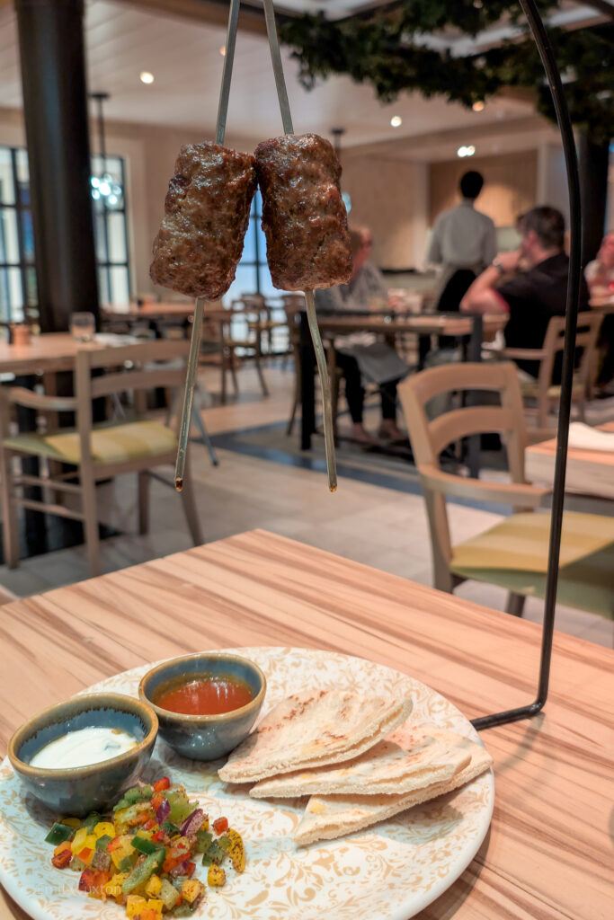 Hanging kebab with a plate of pitta and peppers