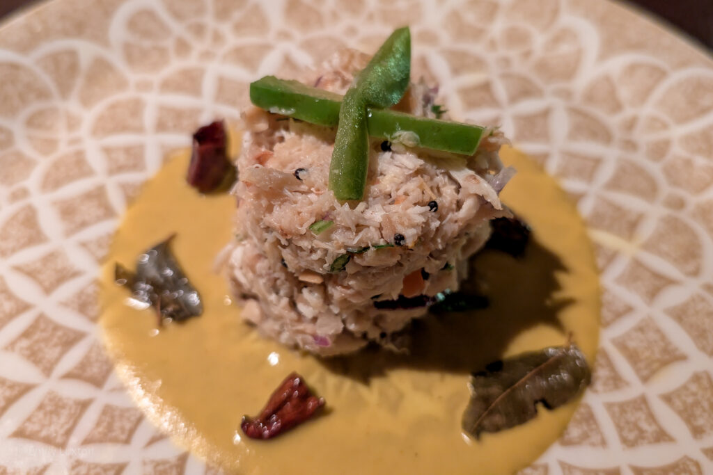 Terrine of crab meat with green peppers on top and a yellow sauce around