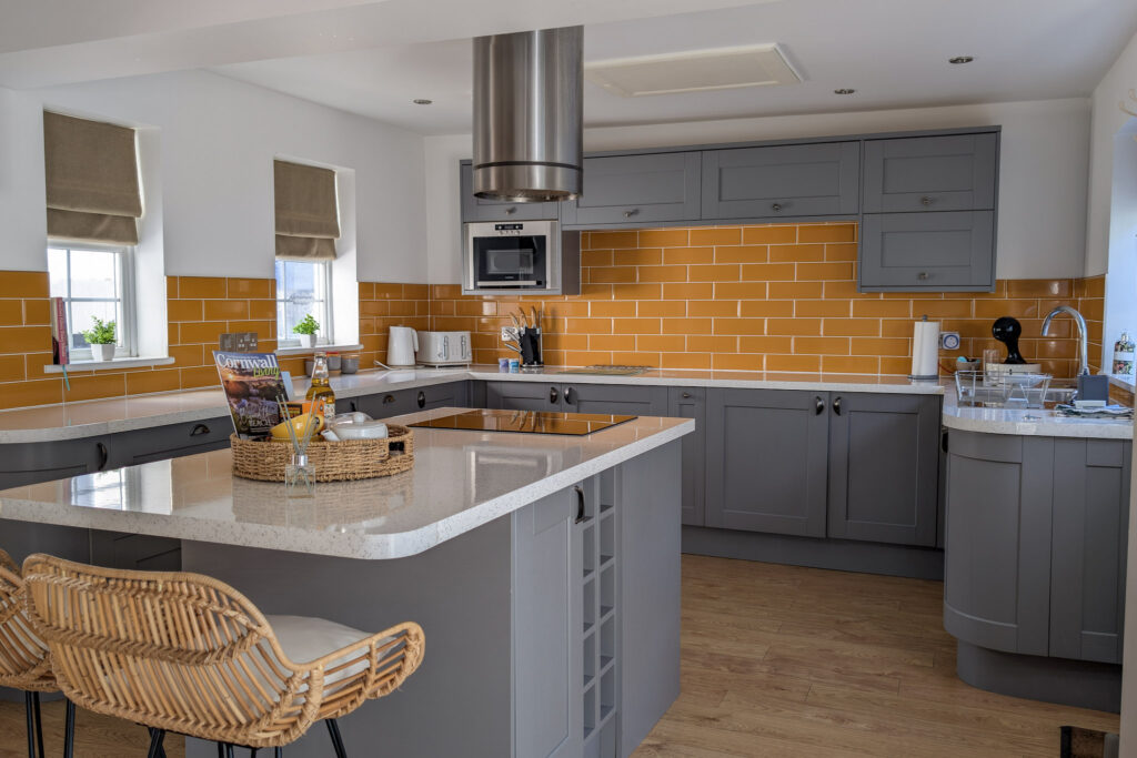 Large kitchen with grey cabinets and mustard yellow tiles