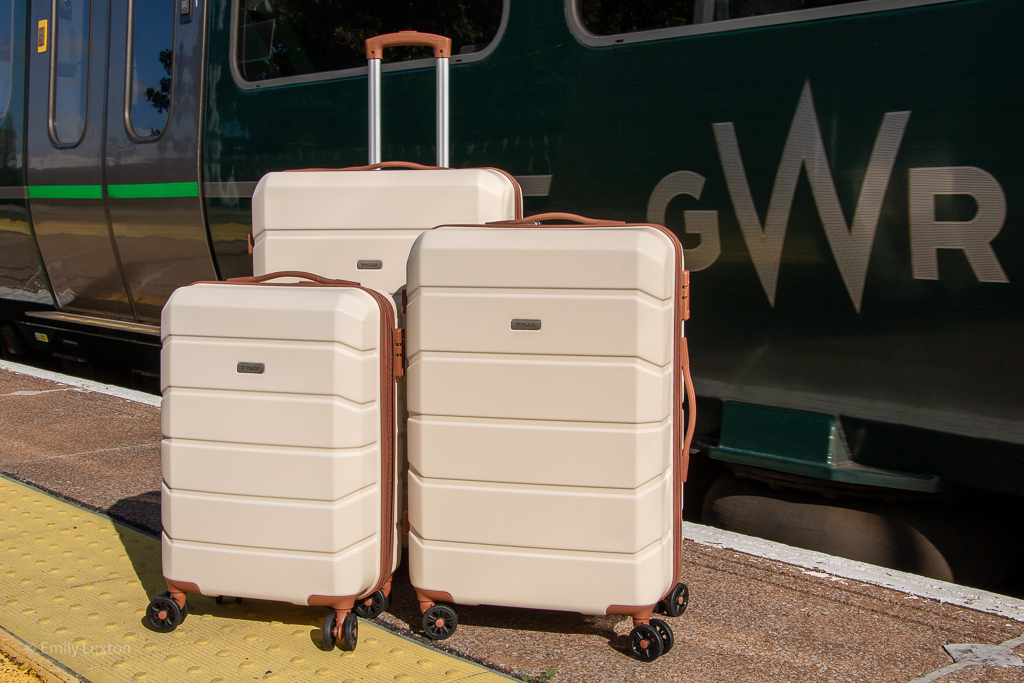 3 cream suitcases with brown trim on a station platform with a green GWR train behind | Tavoxda luggage review