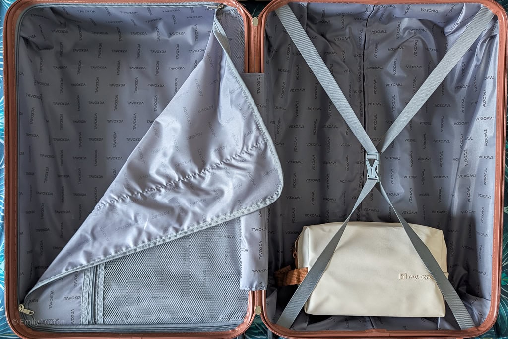 Interior of Tavoxda hard shell suitcase with greay material and a cream toiletry bag
