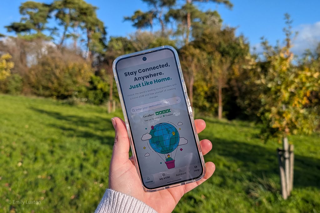 Hand holding a phone with the Sim local app homescreen